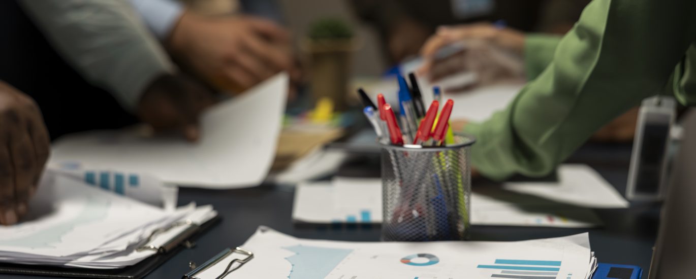 HabtAudit – Independent Audit & Advisory Firm in Ethiopia | close up diverse business team exchanging insights forecasting diagrams late night